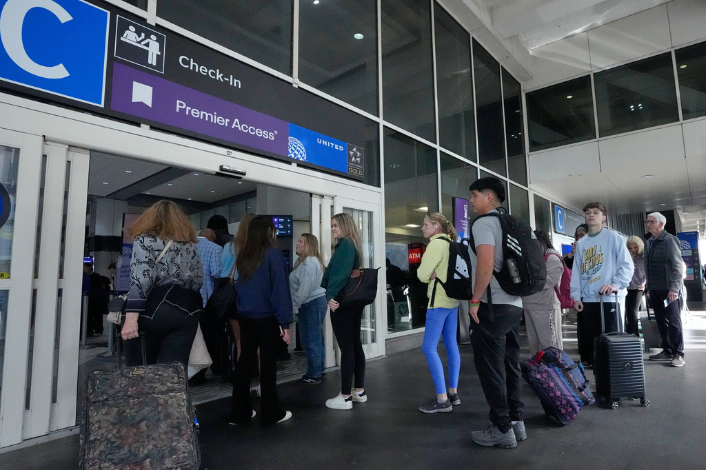 FILE - Passengers wait in long security checkpoint lines outside a terminal at George Bush Intercontinental Airport, Thursday, March 19, 2026, in Houston. (AP Photo/David J. Phillip, File)
