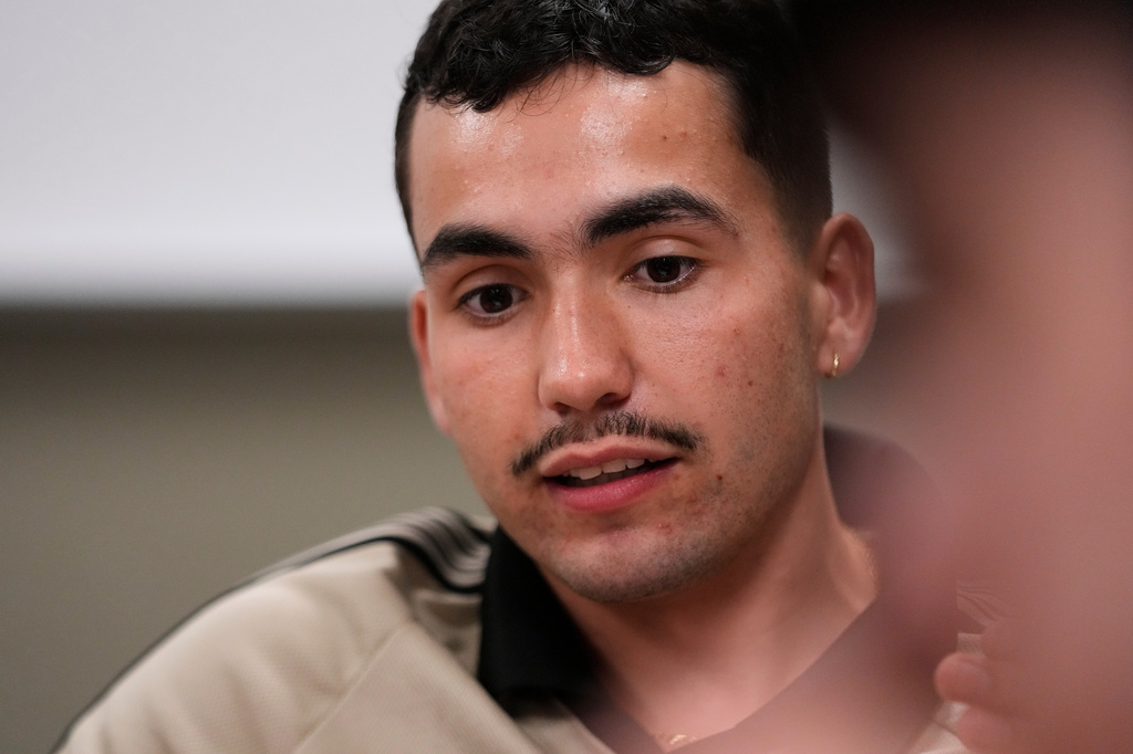 Michigan State University senior Frankie Llerandi listens to a discussion at a campaign event for William Lawrence, the Democratic candidate for U.S. House of Representatives in Michigan's 7th District, on Sept. 15, 2026, in East Lansing, Mich. (AP Photo/Paul Sancya)