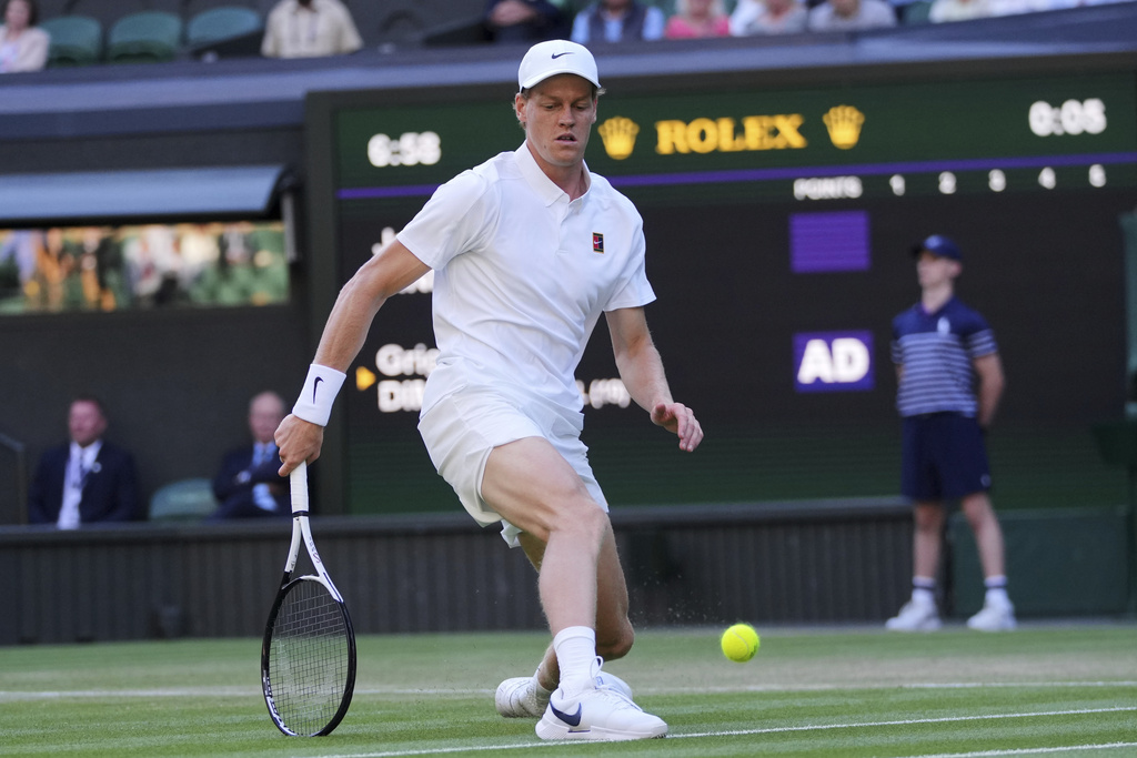 Italy's Jannik Sinner slides in to kick a ball he could not retrieve against Bulgaria's Grigor Dimitrov during a fourth round men's singles match at the Wimbledon Tennis Championships in London, Monday, July 7, 2025. (AP Photo/Kin Cheung)
