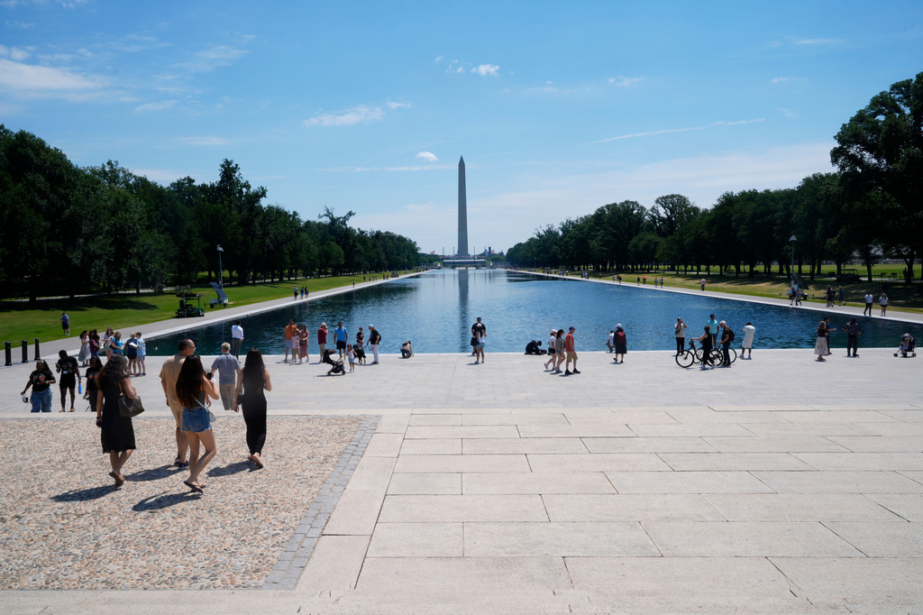 Visitors on the National Mall walk around the Reflecting Pool, between the Lincoln Memorial and the Washington Monument, Thursday, June 25, 2026, in Washington. (AP Photo/Manuel Balce Ceneta)