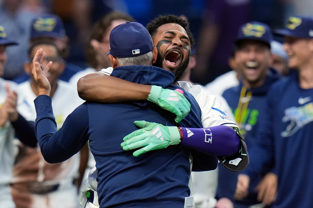 Tampa Bay Rays third baseman Junior Caminero, right, hugs manager Kevin Cash after the team defeated the Houston Astros during a baseball game Friday, Sept. 11, 2026, in St. Petersburg, Fla. (AP Photo/Chris O'Meara)