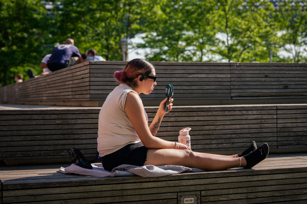 FILE - A person uses a fan during a heat advisory in the Brooklyn borough of New York, May 19, 2026. (AP Photo/Adam Gray, File)