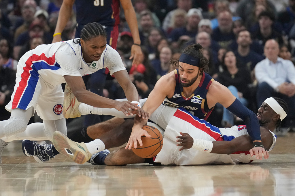 Detroit Pistons' Ausar Thompson, left, and Cleveland Cavalirs' Max Strus, center, reach for the ball over Caris LeVert, right, in the first half of Game 6 of a second-round NBA basketball playoffs series Friday, May 15, 2026, in Cleveland. (AP Photo/Sue Ogrocki)