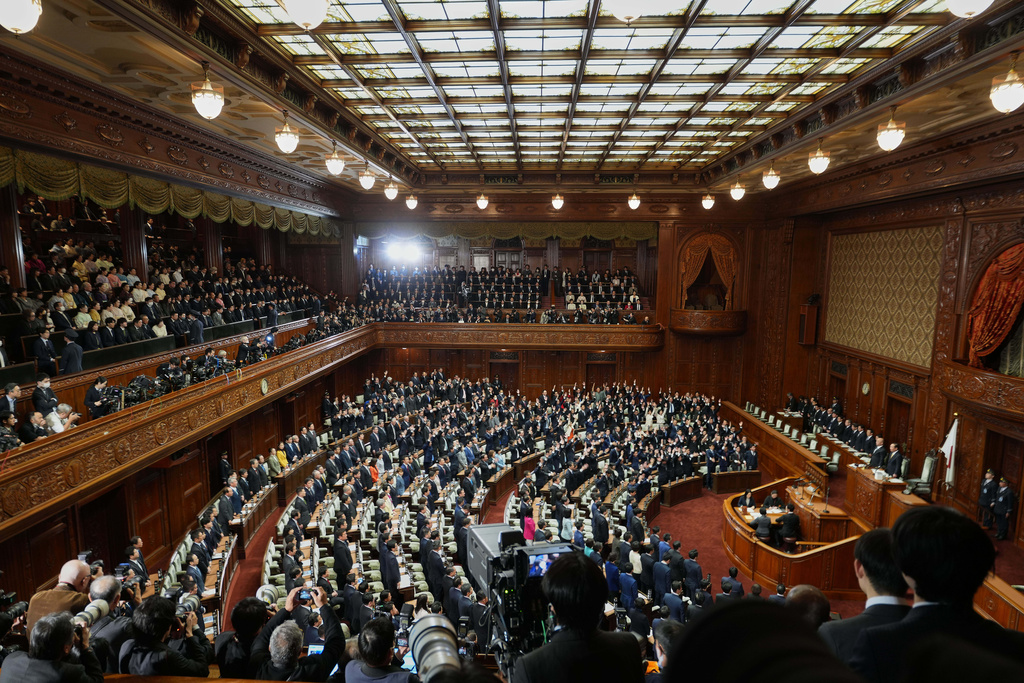 Lawmakers stand after dissolving the lower house, during an extraordinary Diet session at the lower house of parliament Friday, Jan. 23, 2026, in Tokyo. (AP Photo/Eugene Hoshiko)