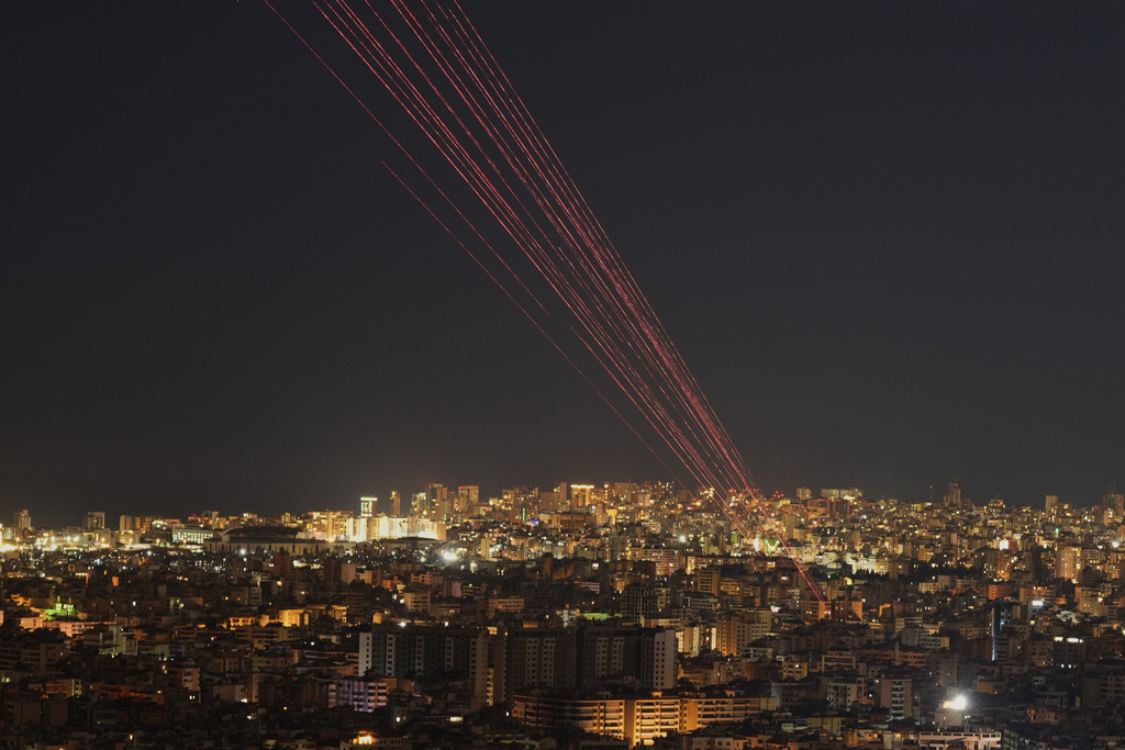 Tracer rounds light the sky as people fire live rounds into the air during a televised speech by Hezbollah leader Naim Kassem in Dahiyeh, Beirut's southern suburbs, Lebanon, Wednesday, March 4, 2026. (AP Photo/Hassan Ammar)