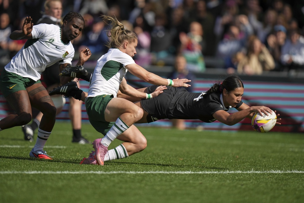 New Zealand's Braxton Sorensen-McGee, right, scores a try as South Africa's Nadine Roos, center, tries to defend during the Women's Rugby World Cup 2025 quarterfinal match between New Zealand and South Africa, in Exeter, England, Saturday, Sept. 13, 2025. (AP Photo/Alastair Grant)