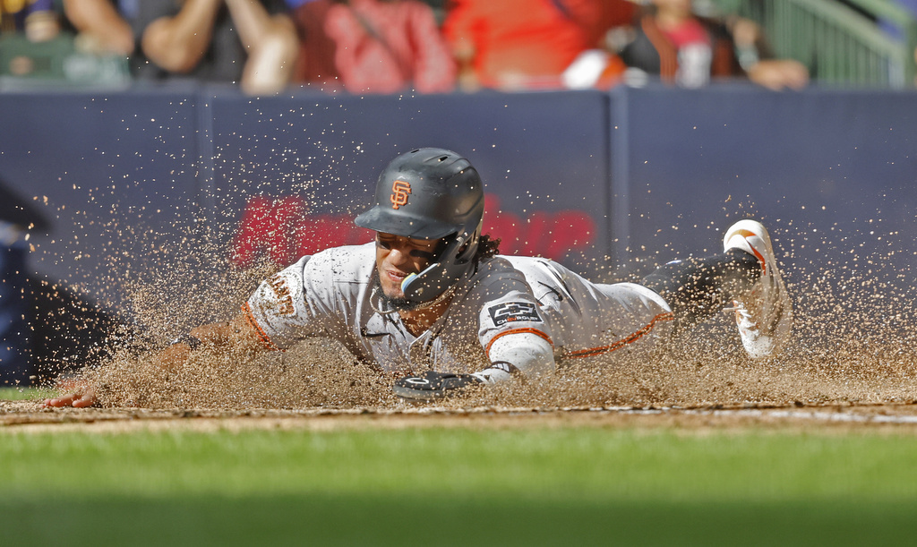 San Francisco Giants' Luis Matos slides in safely to home plate during the ninth inning of a baseball game against the Milwaukee Brewers, Sunday, Aug. 24, 2025, in Milwaukee. (AP Photo/Jeffrey Phelps)