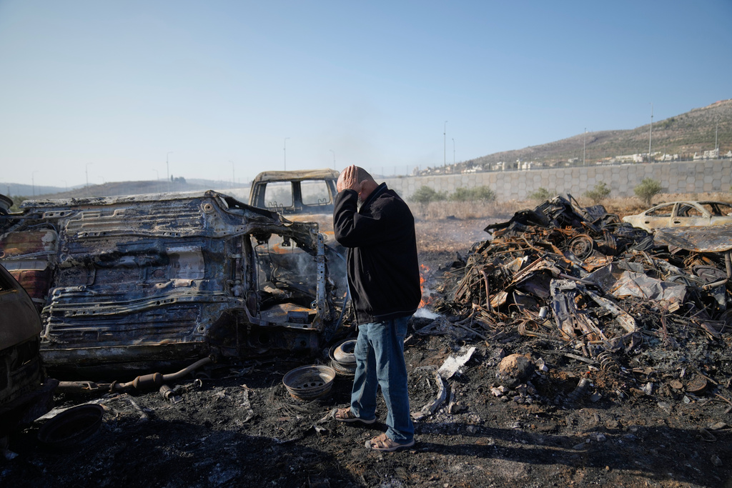 Mohammad Dalal looks at scorched cars in his scrapyard that was set ablaze the night before by who local residents alleged were Israeli settlers in the town of Huwara near the West Bank city of Nablus, Friday, Nov. 21, 2025. (AP Photo/Nasser Nasser)