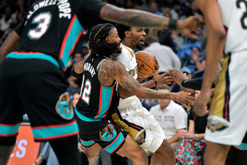 New Orleans Pelicans forward Herb Jones, center right, handles the ball against Memphis Grizzlies guard Ja Morant (12) in the first half of an NBA basketball game Wednesday, Oct. 22, 2025, in Memphis, Tenn. (AP Photo/Brandon Dill)