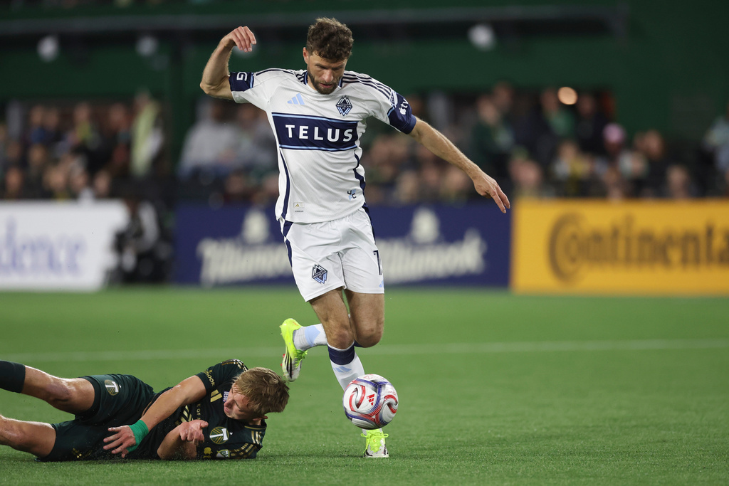 Vancouver Whitecaps forward Thomas Müller, right, dribbles past Portland Timbers' Eric Izoita, left, during the first half of an MLS soccer match, Saturday, March 7, 2026, in Portland, Ore. (AP Photo/Amanda Loman)