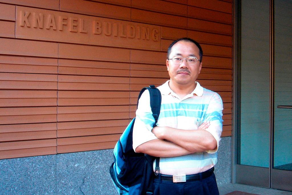 In this photo taken June 2007 and released by Dong Family, Chinese veteran journalist Dong Yuyu poses for a photo in front of the Knafel buulding in Cambridge Massachusetts near Boston in the United States. (Dong Family via AP)
