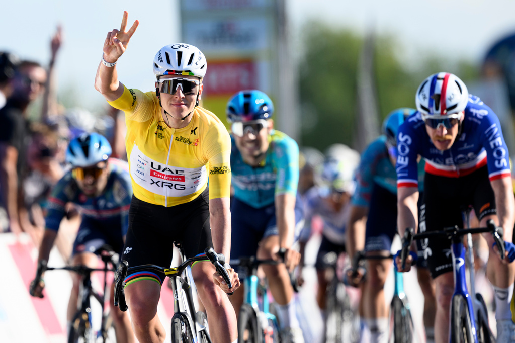 Winner Tadej Pogacar, left, from Slovenia, celebrates ahead of second placed Dorion Godon, right, from France, to win the second stage, a 173,1 km race between Rue and Vucherens, of the 79th Tour de Romandie UCI World Tour Cycling race, in Vuillens, Switzerland, Thursday, April 30, 2026. (Laurent Gillieron/Keystone via AP)