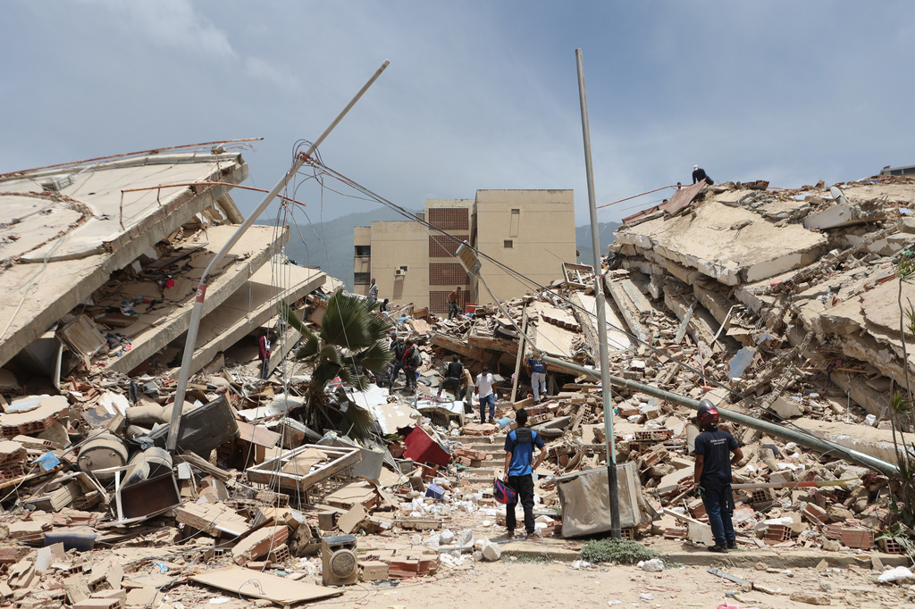 Residents search through the rubble of homes damaged during an earthquake and several aftershocks that struck La Guaira, Venezuela, Thursday, June 25, 2026. (AP Photo/Pedro Mattey)