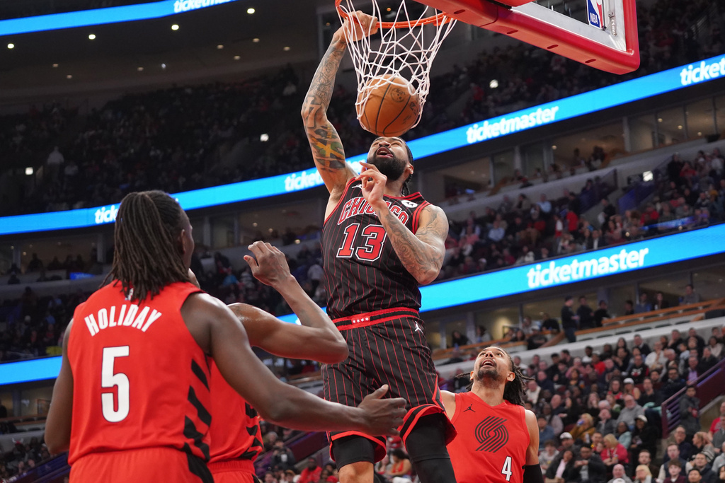 Chicago Bulls center Nick Richards (13) dunks the ball on Portland Trail Blazers guard Jrue Holiday (5) during the second half in an NBA basketball game Thursday, Feb. 26, 2026, in Chicago. (AP Photo/David Banks)