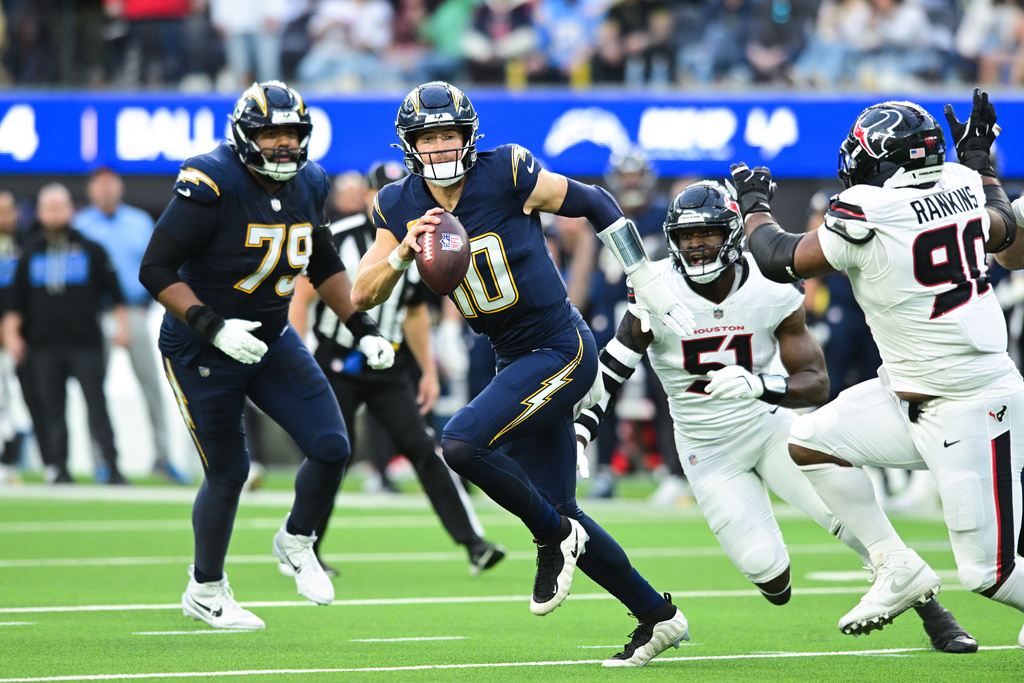 Los Angeles Chargers quarterback Justin Herbert (10) runs with the ball during the first half of an NFL football game against the Houston Texans Saturday, Dec. 27, 2025, in Inglewood, Calif. (AP Photo/Wally Skalij)