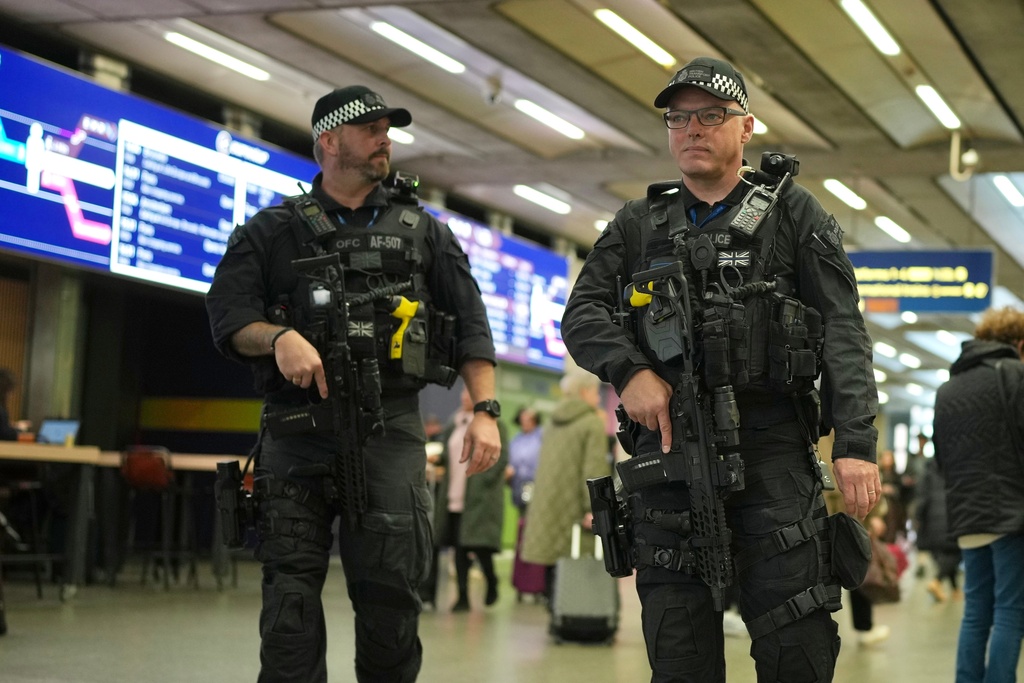 Armed police officers patrol the St Pancras International train station, in London, England, Monday, Nov. 3, 2025. (AP Photo/Kin Cheung)