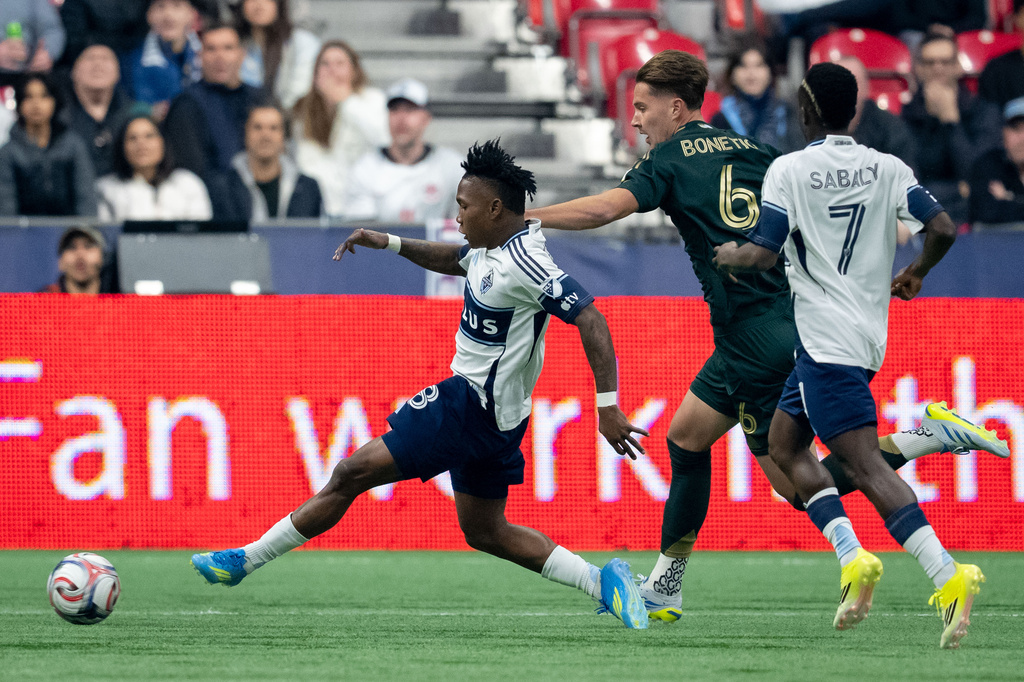 Vancouver Whitecaps' Edier Ocampo (18) scores as teammate Cheikh Sabaly (7) and Portland Timbers' Alex Bonetig (6) watch during the first half of an MLS soccer match in Vancouver, British Columbia, on Saturday, April 4, 2026. (Ethan Cairns/The Canadian Press via AP)
