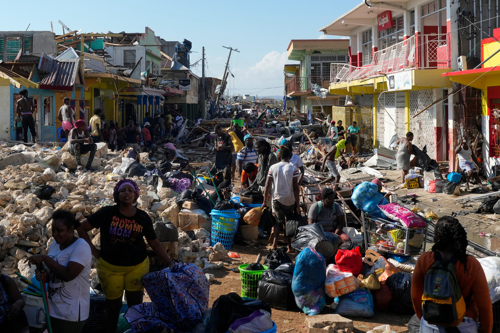 Residents gather amid debris in the aftermath of Hurricane Melissa on a street in Black River, Jamaica, Thursday, Oct. 30, 2025. (AP Photo/Matias Delacroix)