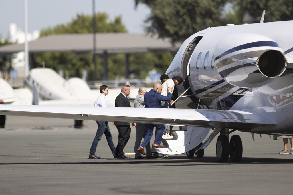 Harjinder Singh is escorted to an airplane by Florida Lt. Gov. Jay Collins and law enforcement on Thursday, Aug. 21, 2025, in Stockton, Calif. (AP Photo/Benjamin Fanjoy)