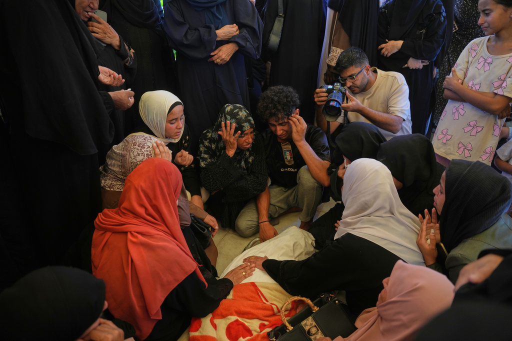 Mourners cry while they take the last look at the body of Palestinian Islam Moussa, 15, who was killed in an Israeli airstrike, during her funeral in Khan Younis, southern Gaza Strip, Saturday, June 27, 2026. (AP Photo/Abdel Kareem Hana)