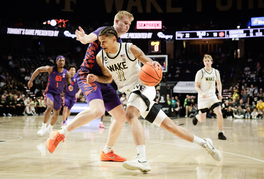 Wake Forest's Marqus Marion (11) works around the defense of Clemson's Chase Thompson (3) in the first half of an ACC men's basketball game, Wednesday, Feb. 18, 2026, in Winston-Salem, N.C. (Allison Lee Isley/The Winston-Salem Journal via AP)