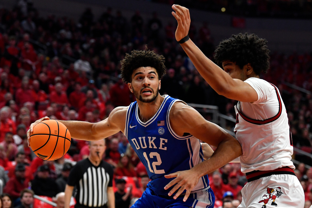 Duke forward Cameron Boozer (12) fights his way through the defense of Louisville forward Sananda Fru (13) during the first half of an NCAA college basketball game in Louisville, Ky., Tuesday, Jan. 6, 2026. (AP Photo/Timothy D. Easley)