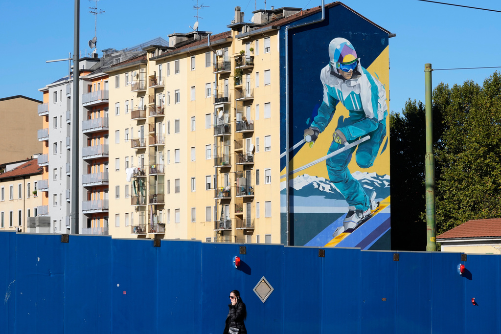A giant mural depicting a skier is displayed on a wall of a building next to the Olympic village, in Milan, Italy, Friday, Oct. 24, 2025. (AP Photo/Luca Bruno)