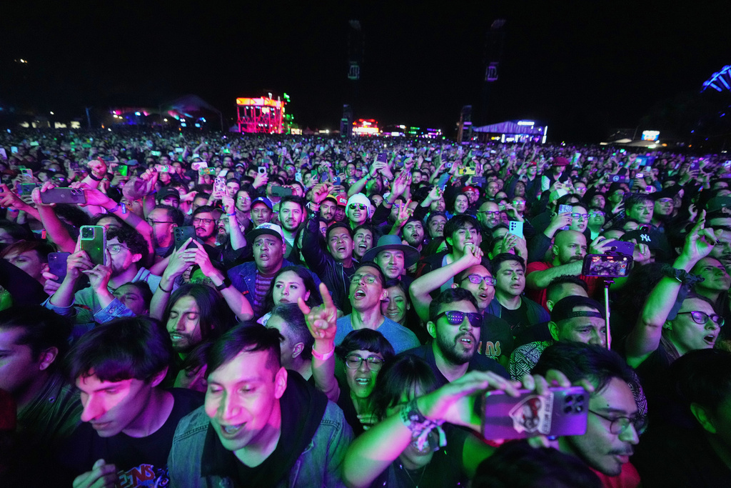 Fans of U.S. rock band Queens of the Stone Age watch his performance during the Corona Capital music festival in Mexico City, Friday, Nov. 14, 2025. (AP Photo/Eduardo Verdugo)