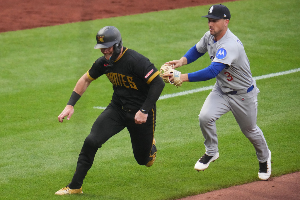 Chicago Cubs third baseman Alex Bregman (3) chases Pittsburgh Pirates' Henry Davis, left, to get an out during a third-inning rundown between third and home during a baseball game in Pittsburgh, Friday, July 24, 2026. (AP Photo/Gene J. Puskar)