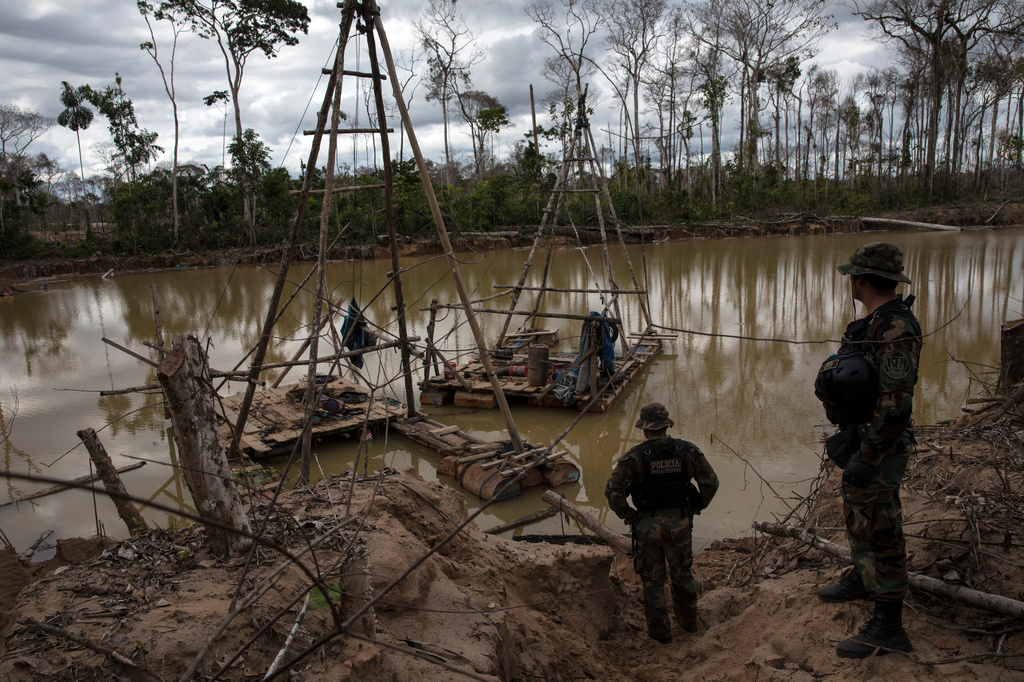 FILE - Police special forces stand next to illegal mining machinery in Peru's Tambopata province on April 1, 2019. (AP Photo/Rodrigo Abd, File)