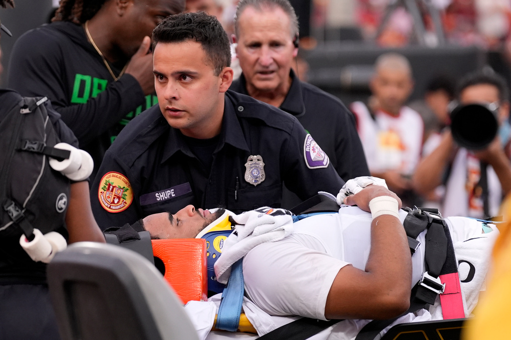 Oregon quarterback Dante Moore, bottom, is loaded into an ambulance following a hard tackle by Southern California linebacker Desman Stephens II during the first half of an NCAA college football game, Saturday, Sept. 26, 2026, in Los Angeles. (AP Photo/Mark J. Terrill)
