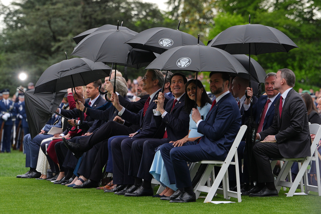 Members of the United States and British delegations use umbrellas at an arrival ceremony on the South Lawn of the White House, Tuesday, April 28, 2026, in Washington. (AP Photo/Julia Demaree Nikhinson)