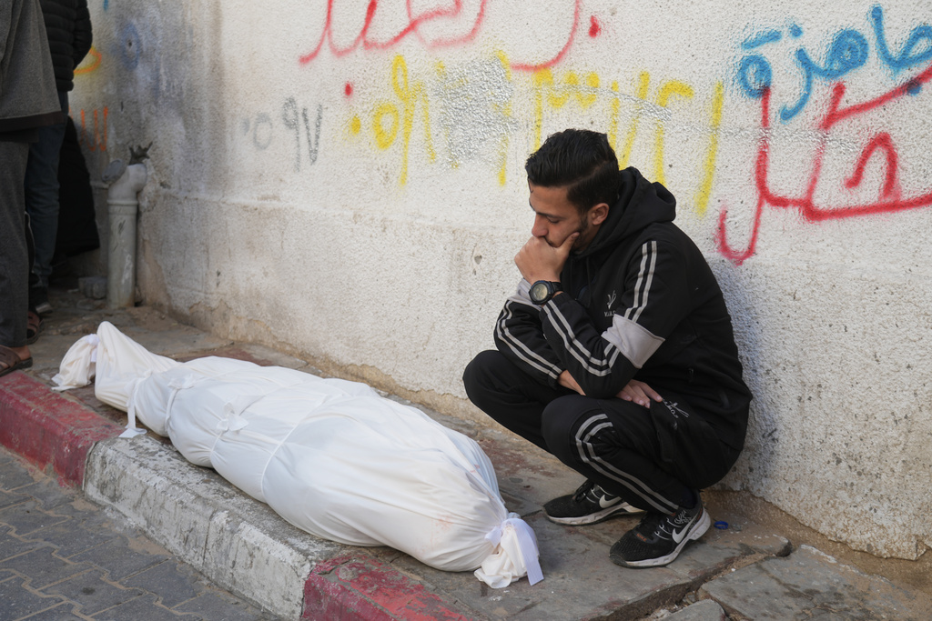 A Palestinian man mourns over Ahmed Haboush, who was killed in an Israeli military strike, at Shifa Hospital in Gaza City, Wednesday, Feb. 4, 2026. (AP Photo/Jehad Alshrafi)