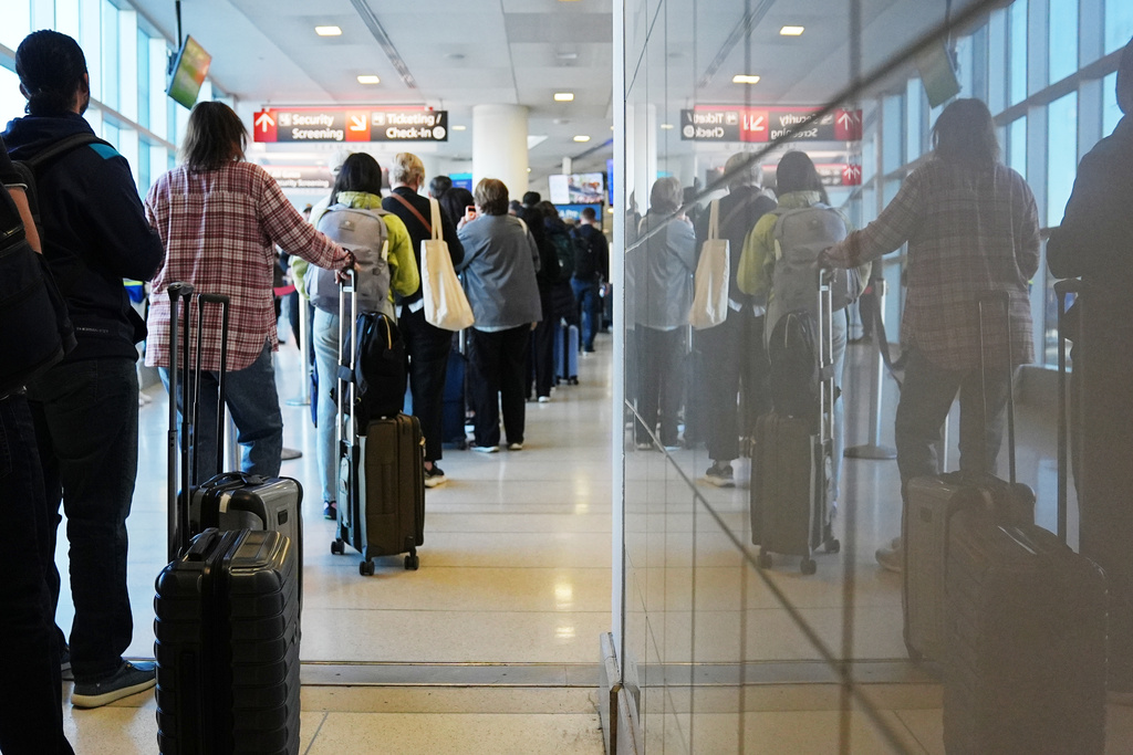 Travelers wait in a security check point line at Philadelphia International Airport, Tuesday, March 24, 2026, in Philadelphia. (AP Photo/Matt Rourke)