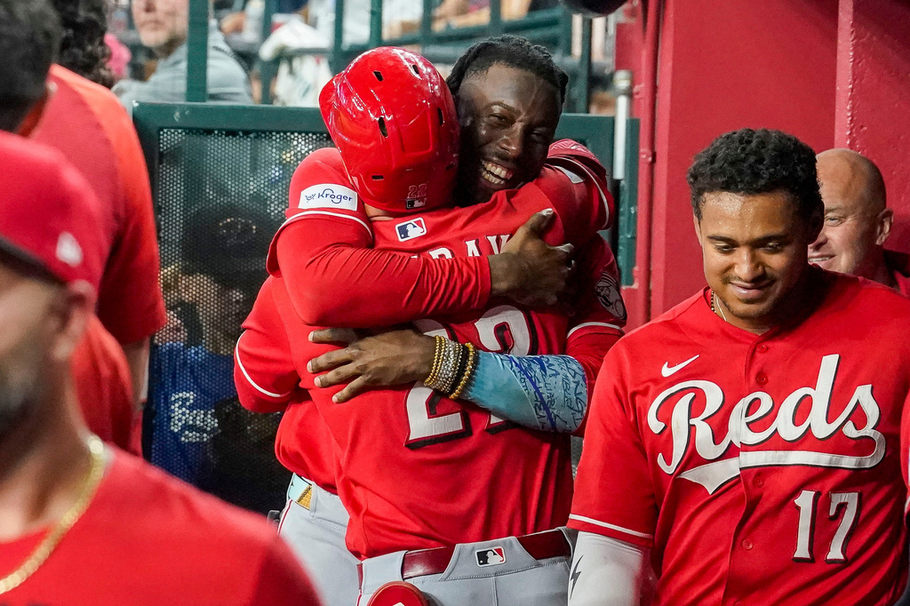 Cincinnati Reds' Elly De La Cruz, center right, hugs JJ Bleday, after Bleday hit for the cycle during the sixth inning of a baseball game against the Arizona Diamondbacks, Saturday, Aug. 22, 2026, in Phoenix. (AP Photo/Darryl Webb)
