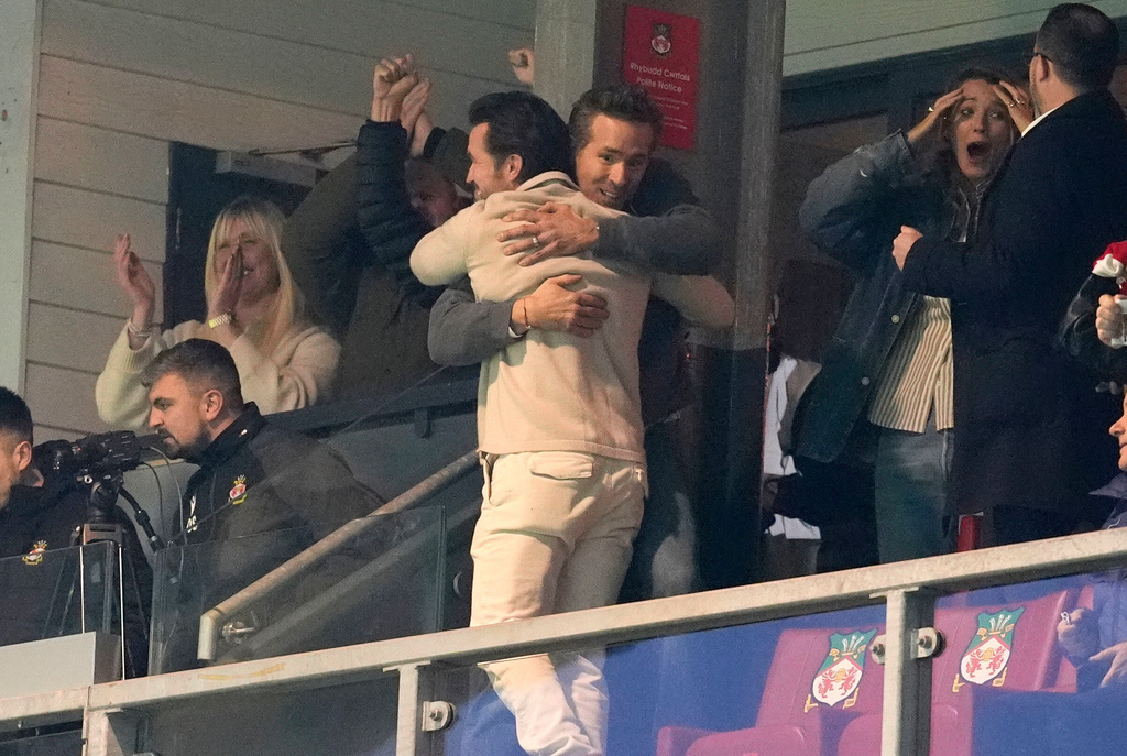 Wrexham co-owners Rob Mac, front, and Ryan Reynolds embrace after Wrexham scored during the fifth round FA Cup soccer match between Wrexham and Chelsea in Wrexham, Wales, Saturday, March 7, 2026. (Nick Potts/PA via AP)