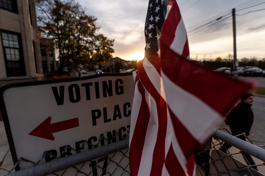 FILE - An American flag flies in the wind as a voter leaves a polling site after casting a ballot on Election Day, Nov. 5, 2024, in Dearborn, Mich. (AP Photo/David Goldman, file)
