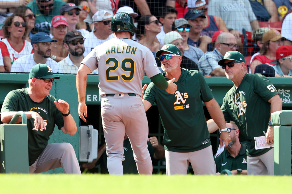 Athletics's Donovan Walton (29) is greeted at the dugout after scoring the winning run during the ninth inning of a baseball game against the Boston Red Sox, Sunday, Aug. 9, 2026, in Boston. (AP Photo/Mark Stockwell)