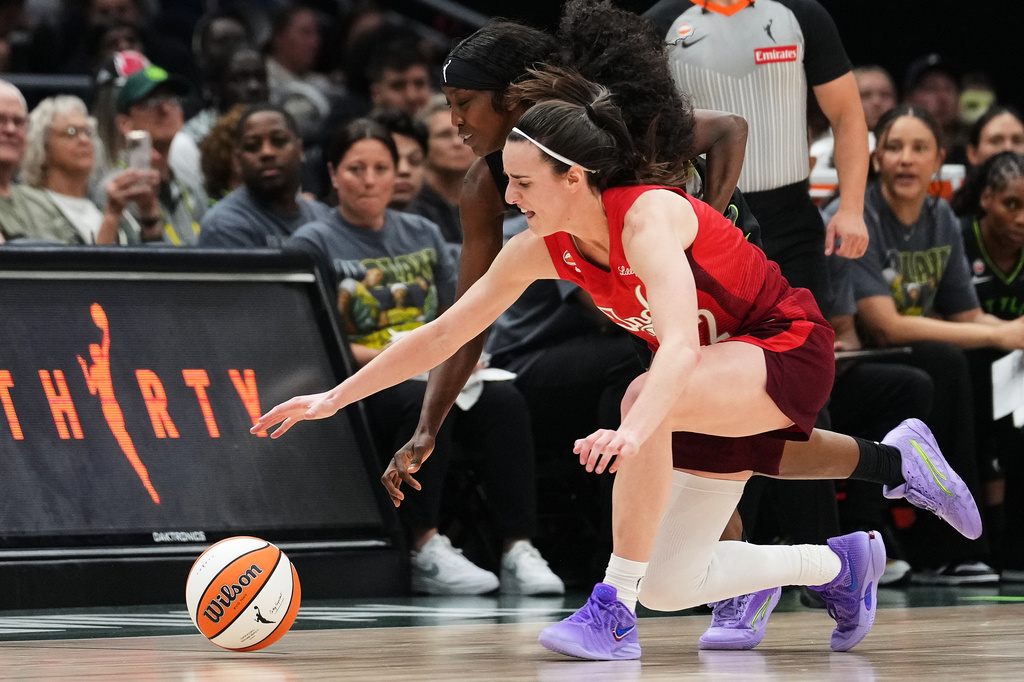 Seattle Storm guard Flau'jae Johnson, back, reaches for the ball against Indiana Fever guard Caitlin Clark, front, during the second half of a WNBA basketball game, Tuesday, July 28, 2026, in Seattle. (AP Photo/Lindsey Wasson)
