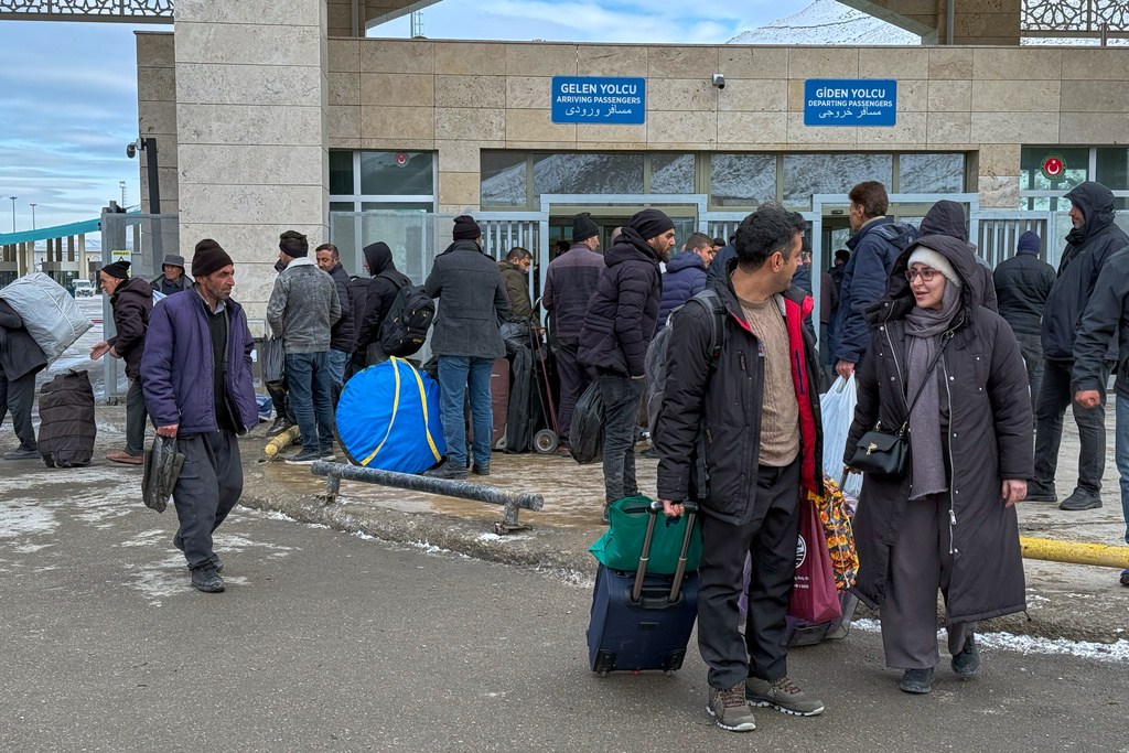 People, mostly Iranians, wait after crossing Kapikoy border post between Turkey and Iran, in Kapikoy, Turkey, Saturday, Jan. 17, 2026. (AP Photo/Serra Yedikardes)