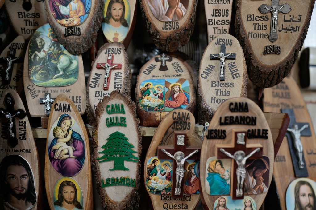 Religious souvenirs displayed for sale at a shop at the site that local tradition identifies as the location of Jesus' first miracle, turning water into wine, in the southern Lebanese village of Qana near the border with Israel, Sunday, Nov. 16, 2025. (AP Photo/Hassan Ammar)