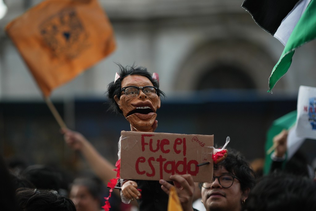 A protester holds a doll representing former President Gustavo Diaz Ordaz during a protest commemorating the anniversary of the 1968 Tlatelolco killings, when soldiers fired on student protesters, in Mexico City, Thursday, Oct. 2, 2025. (AP Photo/Eduardo Verdugo)