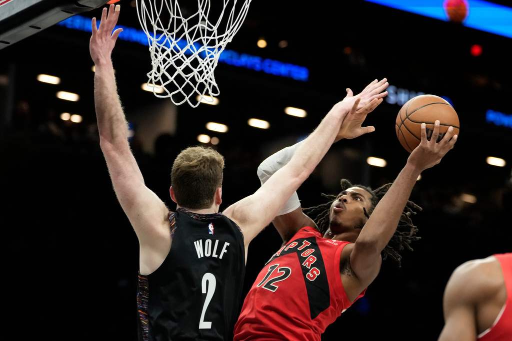 Toronto Raptors forward Collin Murray-Boyles (12) looks to shoot over Brooklyn Nets forward Danny Wolf (2) during the first half of an NBA basketball game, Sunday, Dec. 21, 2025, in New York. (AP Photo/Yuki Iwamura)
