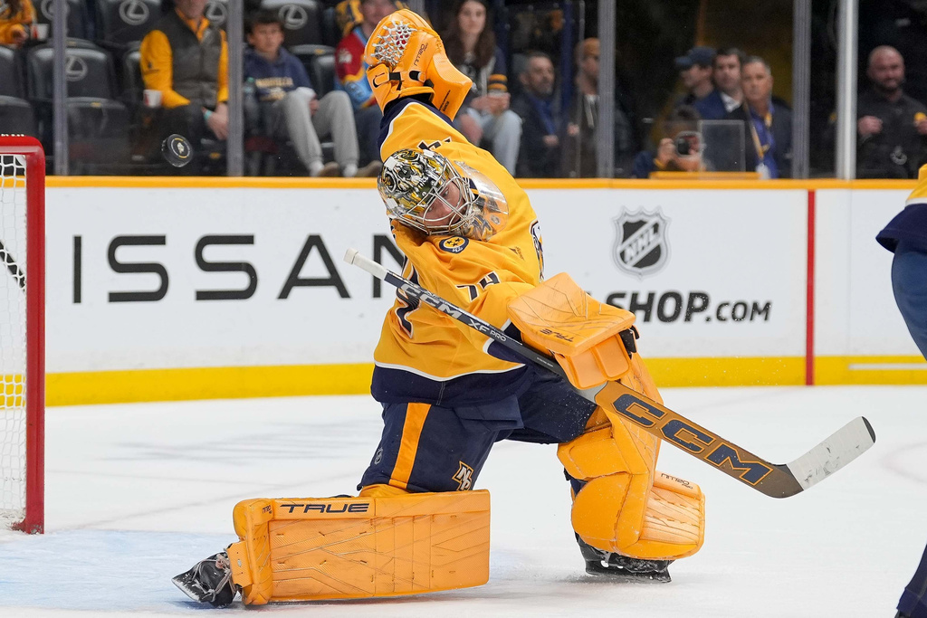 Nashville Predators goaltender Juuse Saros (74) deflects a shot on goal during the first period of an NHL hockey game against the Calgary Flames, Saturday, Nov. 1, 2025, in Nashville, Tenn. (AP Photo/Camden Hall)