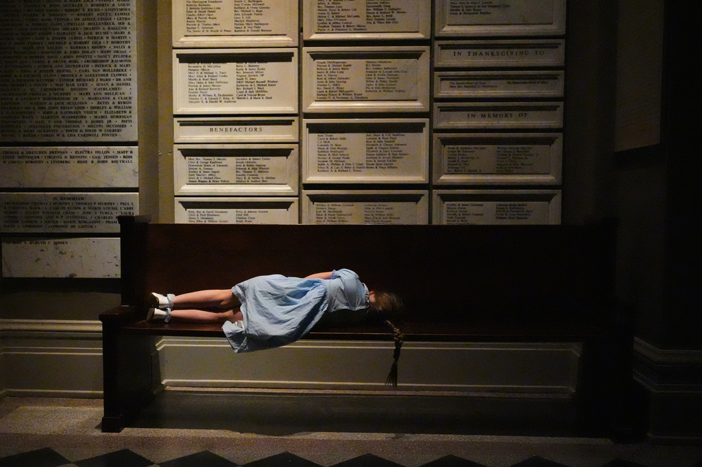 A young worshipper rests on a bench outside the nave of the cathedral during an Easter vigil at St. James Cathedral, Saturday, April 4, 2026, in Seattle. (AP Photo/Lindsey Wasson)