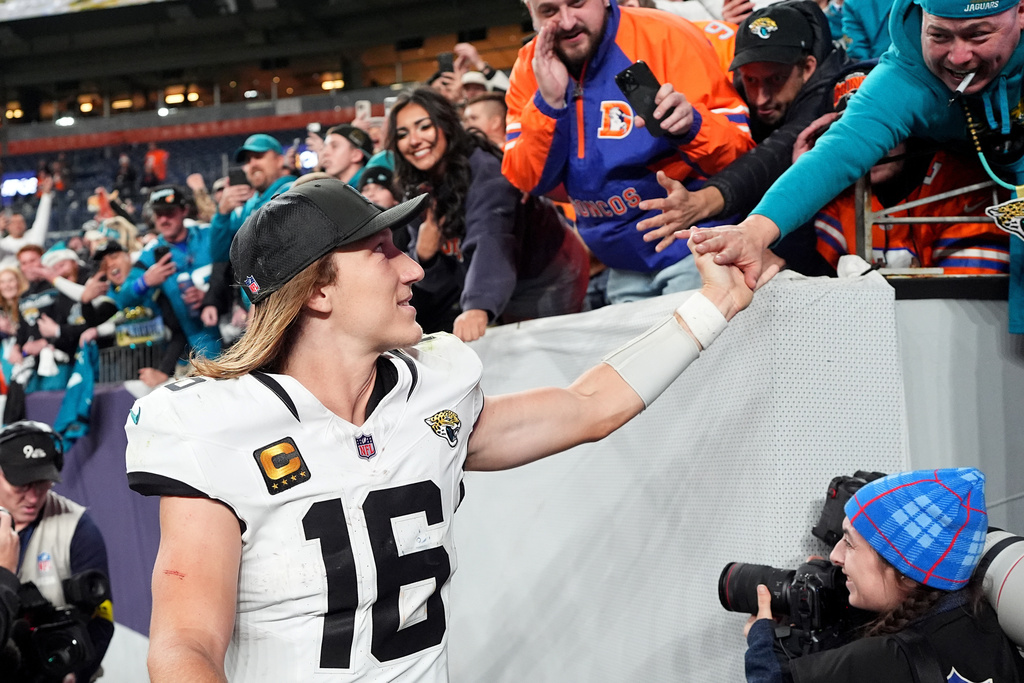 Jacksonville Jaguars quarterback Trevor Lawrence (16) greets fans as he runs off field after an NFL football game against the Denver Broncos in Denver, Sunday, Dec. 21, 2025. (AP Photo/David Zalubowski)