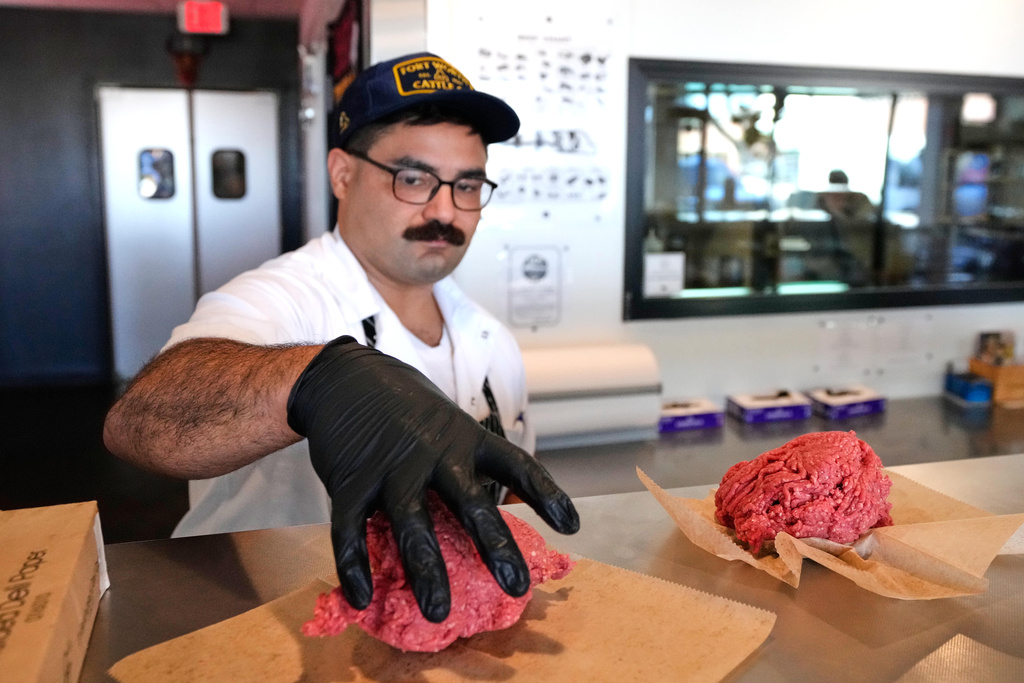 Nate Abeyta, owner and founder of Deep Cuts butcher shop prepares an order of ground meat for a customer, Tuesday, Oct. 21, 2025, in Dallas. (AP Photo/Tony Gutierrez)