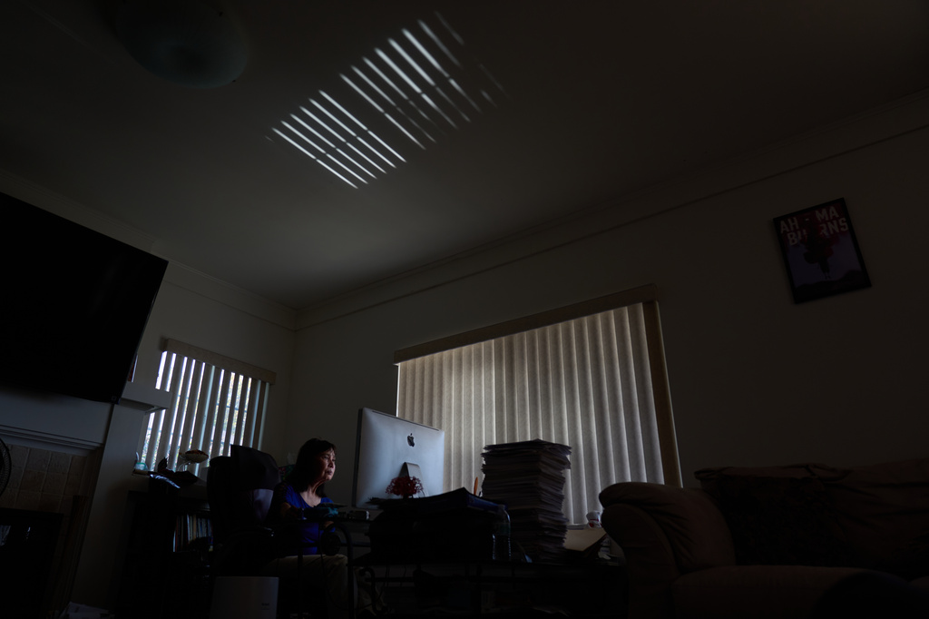 Alice Lin, who fought back to recover some of the $720,000 she and her late husband had saved over their lifetime which was stolen by an online scammer, sits at her computer at home, Saturday, May 9, 2026, in Alhambra, Calif. (AP Photo/David Goldman)