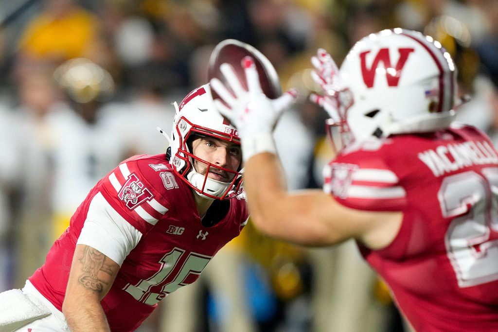 Wisconsin quarterback Hunter Simmons (15) makes a lateral pass to running back Cade Yacamelli, right, during the first half of an NCAA college football game against Iowa, Saturday, Oct. 11, 2025, in Madison, Wis. (AP Photo/Andy Manis)