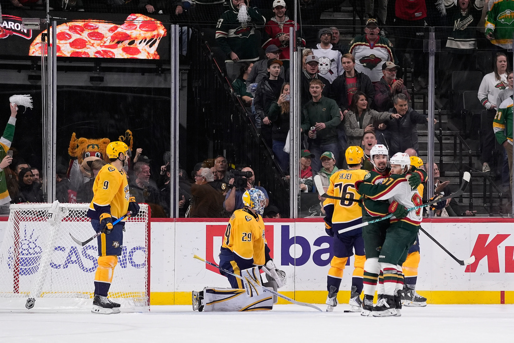 Minnesota Wild left wing Marcus Johansson (90), second right, hugs left wing Kirill Kaprizov (97) after scoring a goal during overtime of an NHL hockey game against the Nashville Predators, Tuesday, Nov. 4, 2025, in St. Paul, Minn. (AP Photo/Abbie Parr)